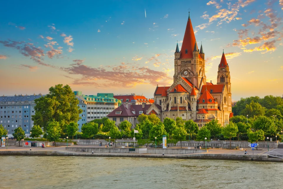 City skyline at sunset with cathedral spire, Vienna, Austria