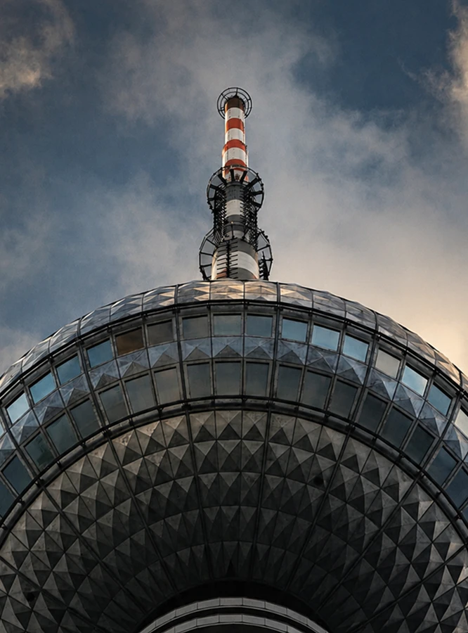 Close-up of a tower spire against a cloudy sky