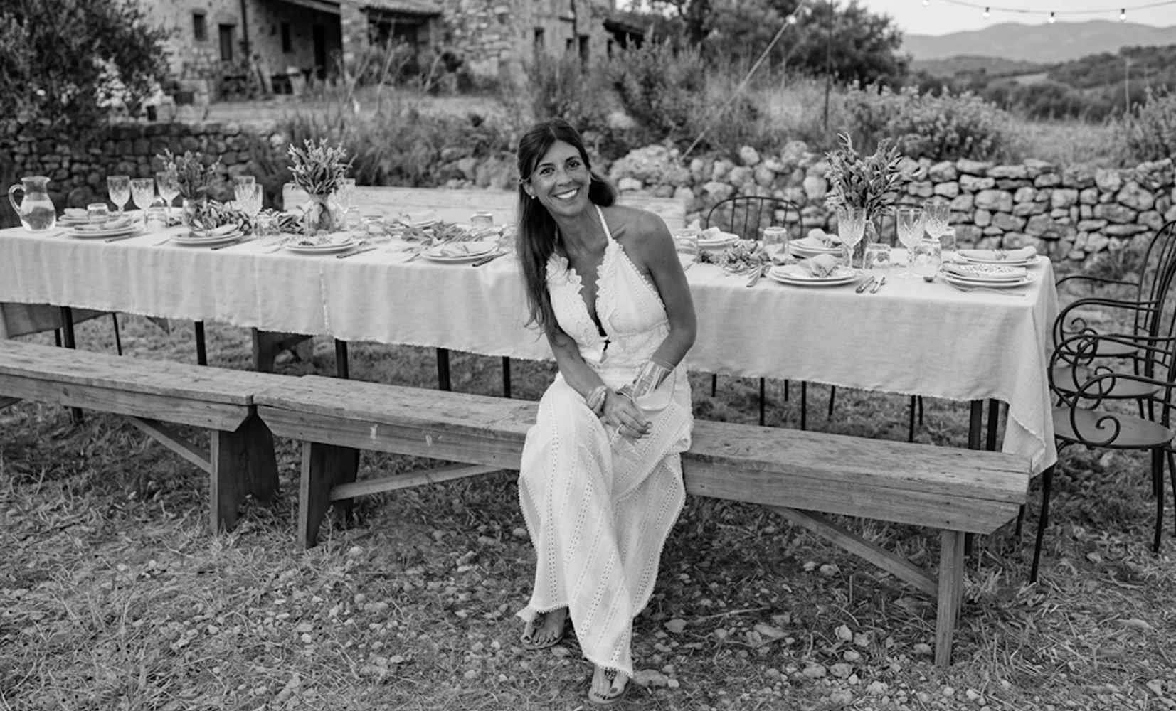 Black and white photo of a guest at an elegantly set outdoor dinner table